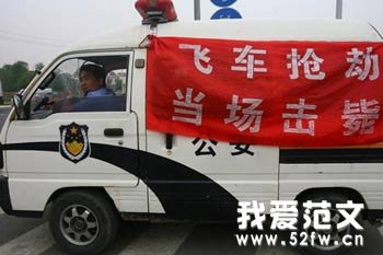 警车上挂起“飞车抢劫当场击毙”红色条幅震慑不法分子。